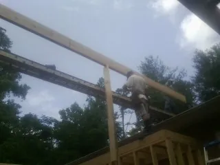 Carpenter setting a ridge beam over a new addition frame — Ice Dam Removal by Roofing Brothers in Cross Hill