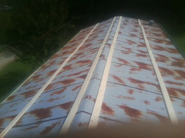 Rusted metal roof panels with new wood purlins before replacement — Storm Damage Roof Repair in Cross Hill by Roofing Brothers
