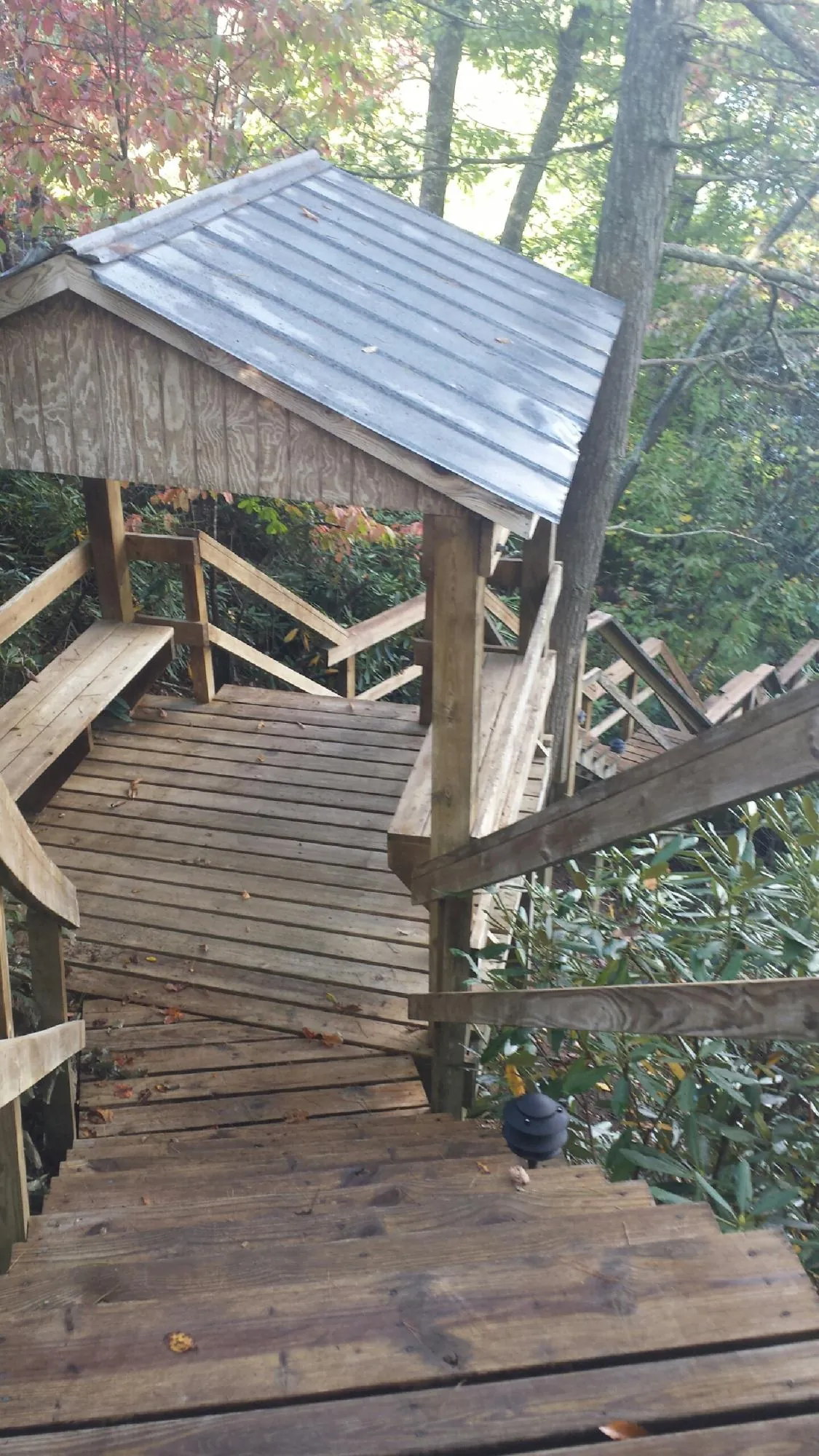 Metal roofed shelter over wooden steps on a wooded walkway — Skylight Repair & Installation work by our crew in Cross Hill