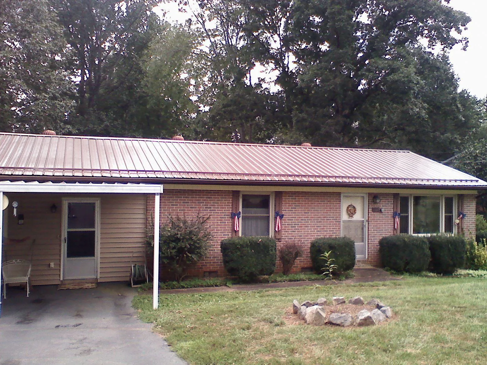 Bronze metal roof and carport on a brick ranch home — Roof Repair work by our crew in Cross Hill