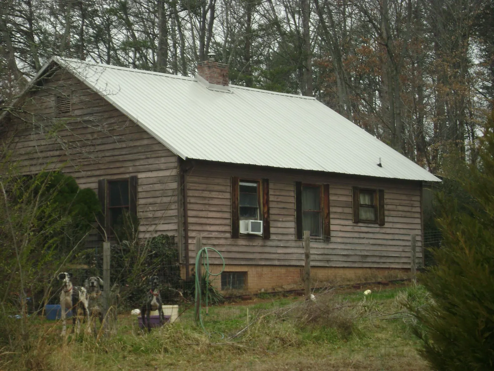 White metal roof on an old wood sided farmhouse, from a Asphalt Shingle Roof Repair job in Cross Hill